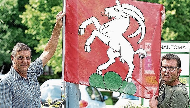 Der Kappeler Gemeindepräsident Jakob Müller, links, und Fahnensponsor Ruedi Berweger hängen eine neue Uerzliker Fahne beim Dorfplatz vis-à-vis des Maxi-Ladens auf. (Bild Martin Platter)