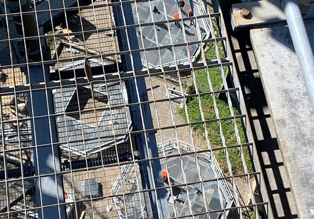 Durch den Gitterboden der Plattform des alten Felseneggturms sind Arbeiter auf den Plattformen des neuen Turms zu sehen. (Bild Stefan Schneiter)