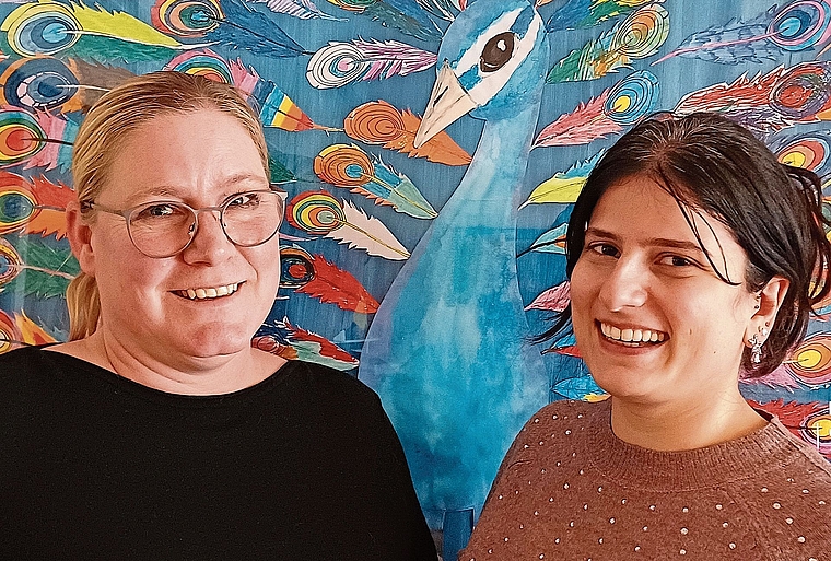 Martina Lack, Schulsozialarbeiterin in Aeugst (links), und Sheyda Shahnazari, Schulsozialarbeiterin in Wettswil, vor einem Gemeinschaftswerk, zu dem an der Schule Aeugst jedes Kind eine Feder beitrug. (Bild Regula Zellweger)