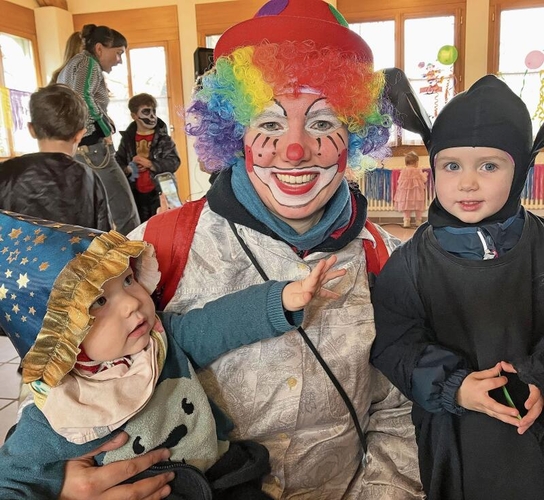 Regenbogen-Clown mit Begleitung.