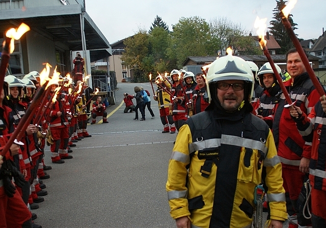 Sichtlich gerührt schreitet Roger Lochmatter durchs Fackel-Spalier der Feuerwehrleute. (Bilder tst./zvg.)