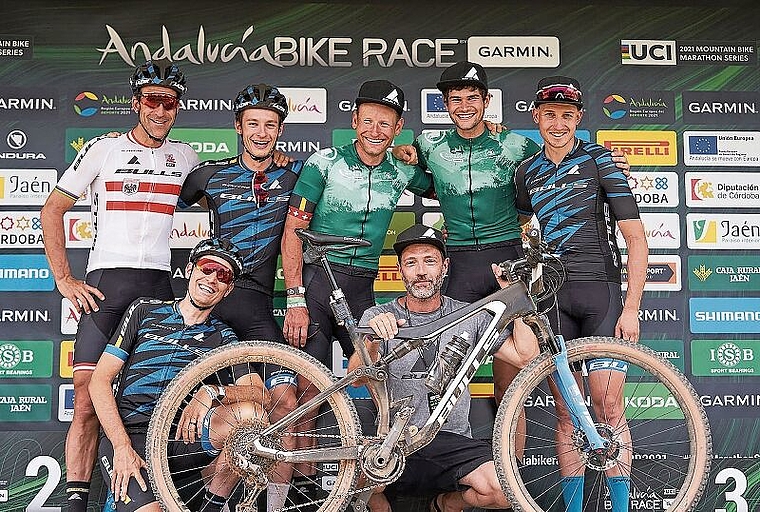 Urs Huber (Bildmitte, stehend) und Simon Schneller (rechts von Huber) lachen umringt von ihrem Teamkollegen als Sieger vom Podium des Andalucia Bike Race. (Bild Sportograf)
