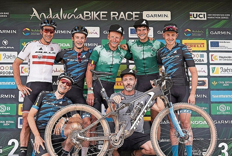Urs Huber (Bildmitte, stehend) und Simon Schneller (rechts von Huber) lachen umringt von ihrem Teamkollegen als Sieger vom Podium des Andalucia Bike Race. (Bild Sportograf)