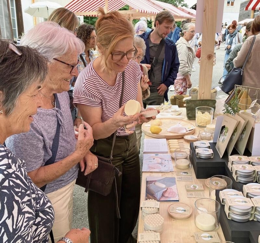 Marktbesucherinnen bewundern die duftenden handgefertigten Seifen der Manufaktur MHplus.