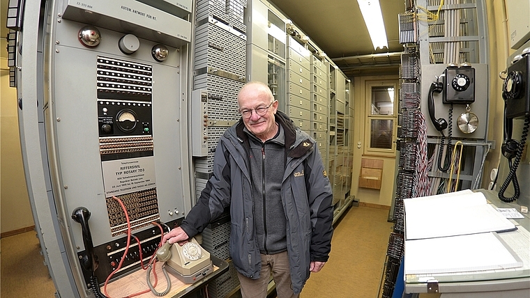 Martin Roth am Hauptterminal der Rifferswiler Telefonzentrale vom Typ Rotary 7D3. Links hinter ihm sind die 600 Zählerblöcke der Abonnenten zu sehen; direkt hinter ihm unter Glas eine Batterie von neun elektromechanischen Drehwählern, die die Tele