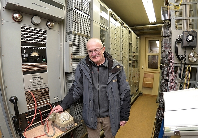Martin Roth am Hauptterminal der Rifferswiler Telefonzentrale vom Typ Rotary 7D3. Links hinter ihm sind die 600 Zählerblöcke der Abonnenten zu sehen; direkt hinter ihm unter Glas eine Batterie von neun elektromechanischen Drehwählern, die die Tele