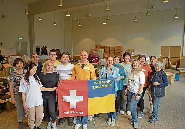 Das Team der NGO «Switlo» am Freitagnachmittag in der Aula der katholischen Kirche Bonstetten, im Hintergrund türmen sich bereits nach kurzer Zeit die kontinuierlich eintreffenden Hilfsgüter. (Bild Salomon Schneider)