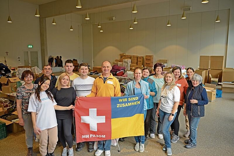 Das Team der NGO «Switlo» am Freitagnachmittag in der Aula der katholischen Kirche Bonstetten, im Hintergrund türmen sich bereits nach kurzer Zeit die kontinuierlich eintreffenden Hilfsgüter. (Bild Salomon Schneider)