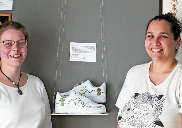 Souraya Hamad (rechts) und Os Rudow vor ihren Werken in der KommBox. Nicht im Bild: Mona Hachem, welche die Schuhe mit Acryl­farben bemalt hat. (Bild Regula Zellweger)