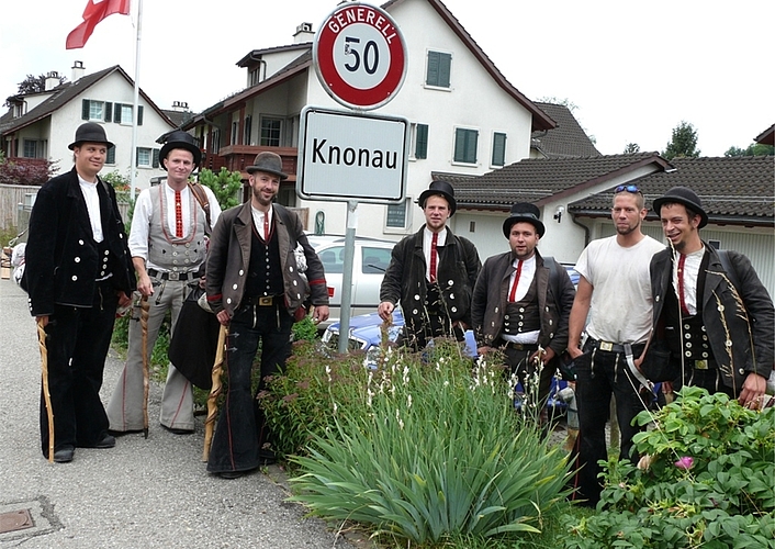 Michael Pfiffner, Zweiter von rechts, mit Wandergesellen an der Ortstafel.Über die Ortstafel klettern ...