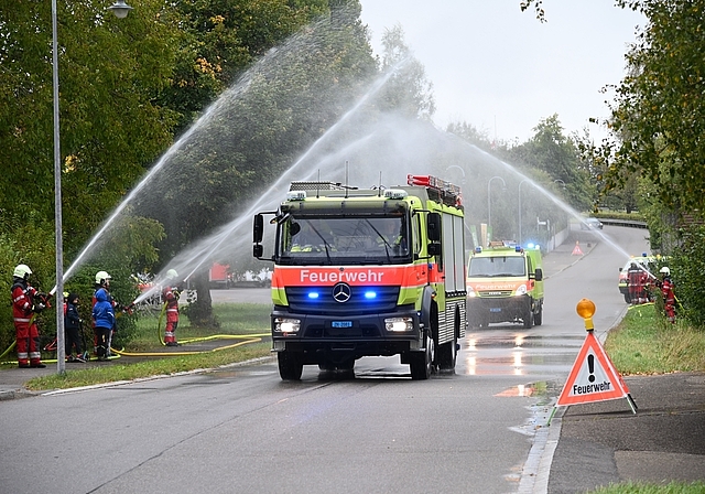 Begrüssung mit einem Wasservorhang: Das neue TLF fährt mit Blaulicht und Martinshorn durch Rifferswil. (Bild Martin Mullis)
