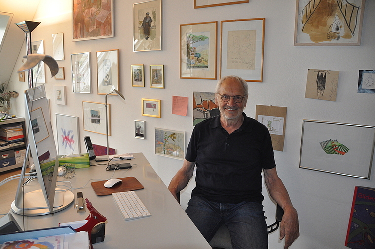 Jubilar Heiner Stolz in seinem Büro mit Bildern von Kunstschaffenden, die er persönlich kennt oder kannte: Tomi Ungerer, H.U. Steger, Katrin Zuzàkova und Jakob Ochsner. (Bild Werner Schneiter)