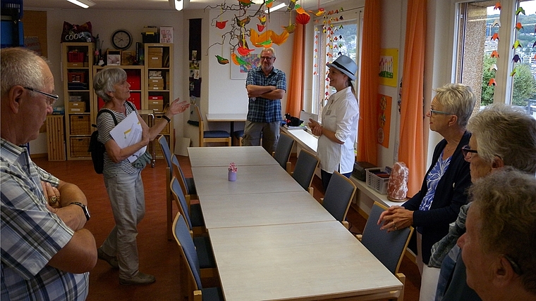 Führung durch das Haus. Die Mitarbeiterin Pamela Koller (mit Hut) unterhält sich im Aktivierungsraum angeregt mit den Gästen. <em>(Bild Marianne Voss)</em>