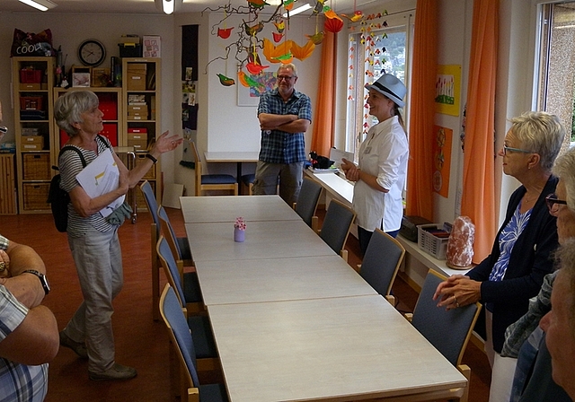 Führung durch das Haus. Die Mitarbeiterin Pamela Koller (mit Hut) unterhält sich im Aktivierungsraum angeregt mit den Gästen. <em>(Bild Marianne Voss)</em>