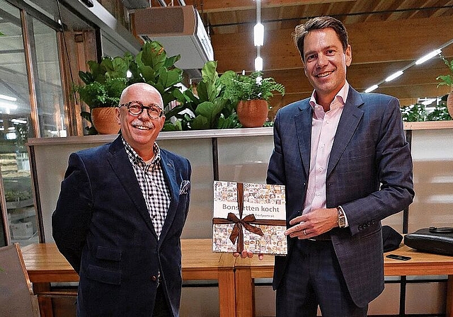 Peter Ehrler, Co-Präsident der FDP Bonstetten (links), überreicht Stefan Brupbacher als Dank für seine Ausführungen ein Kochbuch aus Bonstetten. (Bild Angela Bernetta)