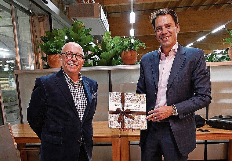 Peter Ehrler, Co-Präsident der FDP Bonstetten (links), überreicht Stefan Brupbacher als Dank für seine Ausführungen ein Kochbuch aus Bonstetten. (Bild Angela Bernetta)
