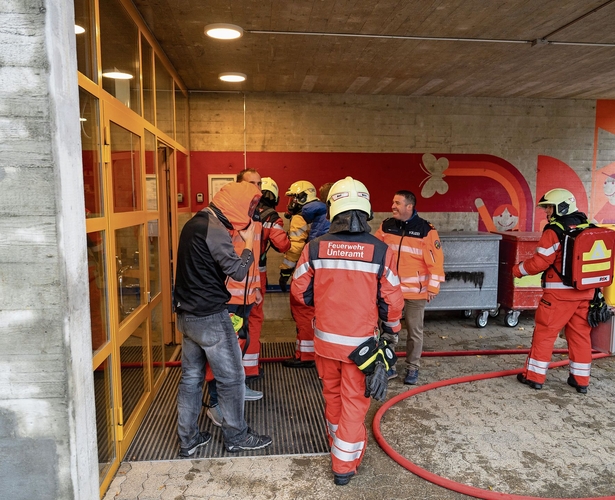 Die Feuerwehr-Sanität wartet vor dem verrauchten Gebäude, um sich den Verletzten zu widmen. Die Feuerwehr-Sanität wartet vor dem verrauchten Gebäude, um sich den Verletzten zu widmen.
