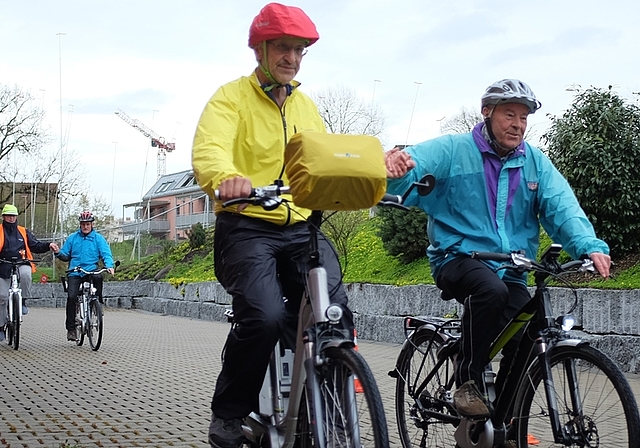 Teilnehmende an der E-Bike Schulung geben sich die Hand, um gleichmässiges, einhändiges Fahren zu üben. (Bild sals)