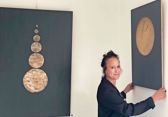Corinne Grau justiert das Bild «Der Mond». Daneben hängt ihr Werk «Turm». (Bild Sandra Isabél Claus)