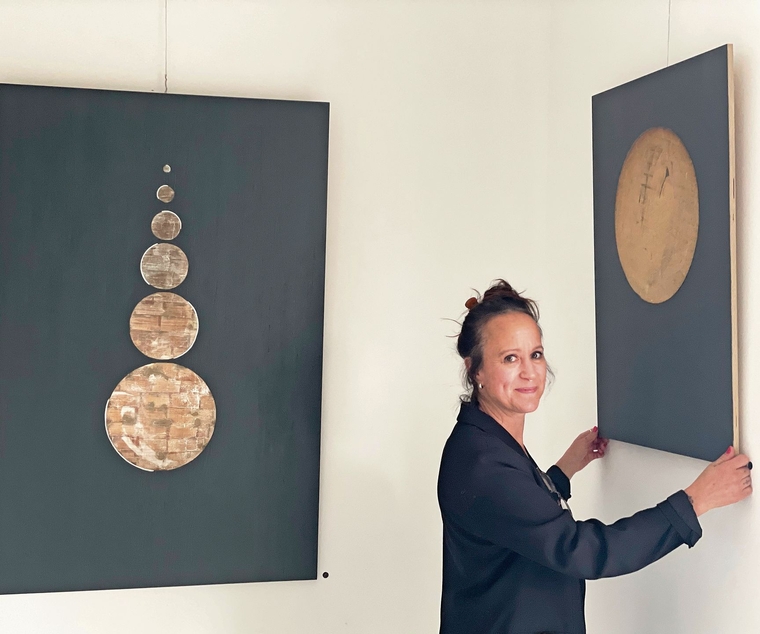 Corinne Grau justiert das Bild «Der Mond». Daneben hängt ihr Werk «Turm». (Bild Sandra Isabél Claus)