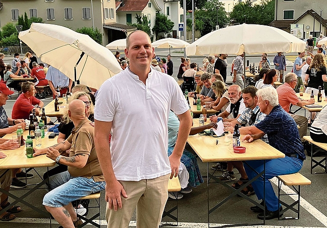 Gemeindepräsident Sven Kammer vor den voll besetzten Festtischen auf dem Löwenplatz. (Bild Marianne Voss)