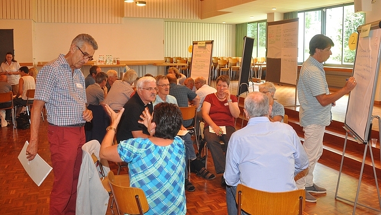 Teilnehmende des Resultat-Workshops scharten sich am Samstag im Bonstetter Gemeindesaal um Flipcharts und diskutierten ausgiebig – auf einem hohen Level, wie der externe Moderator Hanspeter Lienhart feststellte. (Bild Werner Schneiter)