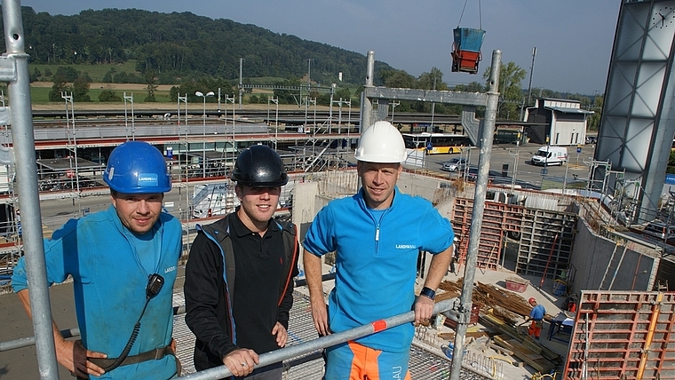 Jetzt geht es in die Höhe: Hochbautechniker Robin Rempfler (Mitte) und die Poliere Thomas Herre (links) und Markus Hochstrasser hoch über der Baustelle für die neue katholische Kirche beim Bahnhof Bonstetten-Wettswil. (Bild Thomas Stöckli)