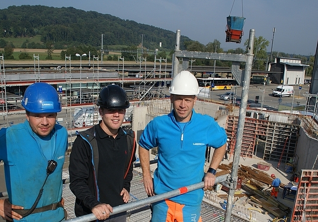 Jetzt geht es in die Höhe: Hochbautechniker Robin Rempfler (Mitte) und die Poliere Thomas Herre (links) und Markus Hochstrasser hoch über der Baustelle für die neue katholische Kirche beim Bahnhof Bonstetten-Wettswil. (Bild Thomas Stöckli)