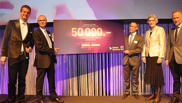 Checkübergabe im Rahmen der Jubiläums-GV, von links: SRF-Moderator Nicolas Senn, der durch das Programm führte; Clientis-Sparcassa-Direktor Marcel Melliger, Ulrich Fausch, Verwaltungsrat; Irene Enderli, Präsidentin Stiftung Spital; und Roland Kun