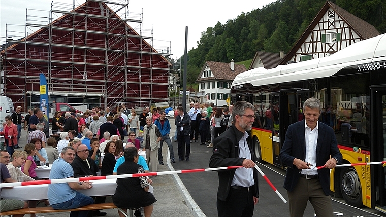 Markus Hegglin, Leiter PostAuto Region Zürich, (rechts) zerschneidet zusammen mit Tiefbauvorstand Christoph Tandler anlässlich der Einweihung das Band. (Bild Marianne Voss)