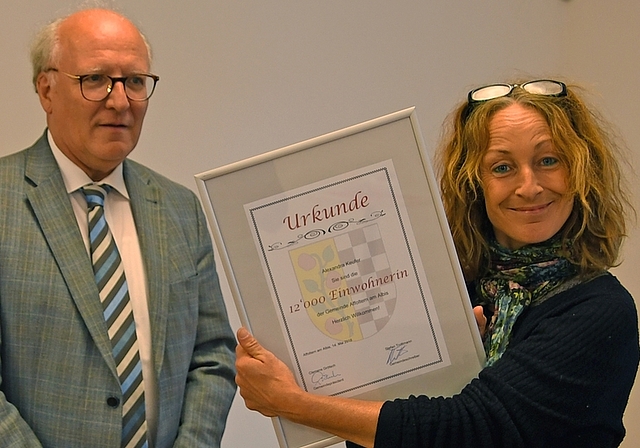 Alexandra Keufer nimmt vom jetzigen Gemeinde- und zukünftigen Stadtpräsident Clemens Grötsch die Urkunde als 12’000. Einwohnerin entgegen. <em>(Bild sals)</em>