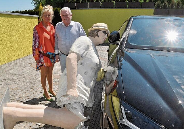 Beklagt einen grossen Schaden: Das Ehepaar Luggen bei der niedergerissenen und nun zerstörten Statue, die beim Umfallen auch noch den Lamborghini in ­Mitleidenschaft gezogen hat. (Bild Werner Schneiter)