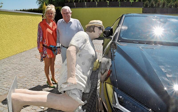 Beklagt einen grossen Schaden: Das Ehepaar Luggen bei der niedergerissenen und nun zerstörten Statue, die beim Umfallen auch noch den Lamborghini in ­Mitleidenschaft gezogen hat. (Bild Werner Schneiter)