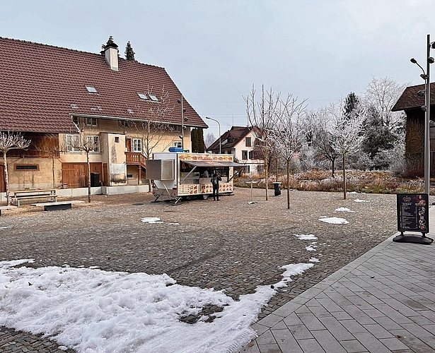 Der im Oktober 2024 fertiggestellte Postarealplatz, unterdessen mit Sitzmöglichkeiten und Imbissstand. Eine weitere Überbauung soll dahinter entstehen.