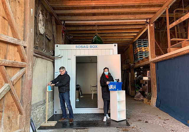 Hausarzt Erich Villiger und Praxiskoordinatorin Kelly Hösli vor dem Container, in dem ab sofort Patienten mit Corona-Symptomen behandelt werden. (Bild Livia Häberling)