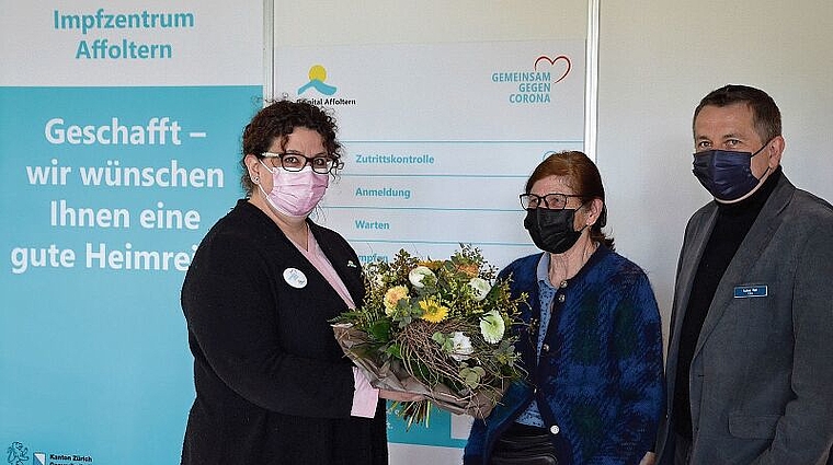 Blumen für die Erste: Ruth Schwob, flankiert von Chefärztin Nadja Lindenmann (links) und CEO Lukas Rist im Impfzentrum