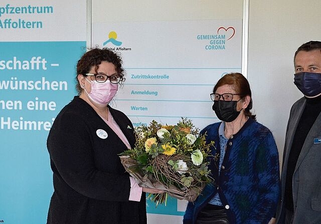 Blumen für die Erste: Ruth Schwob, flankiert von Chefärztin Nadja Lindenmann (links) und CEO Lukas Rist im Impfzentrum 