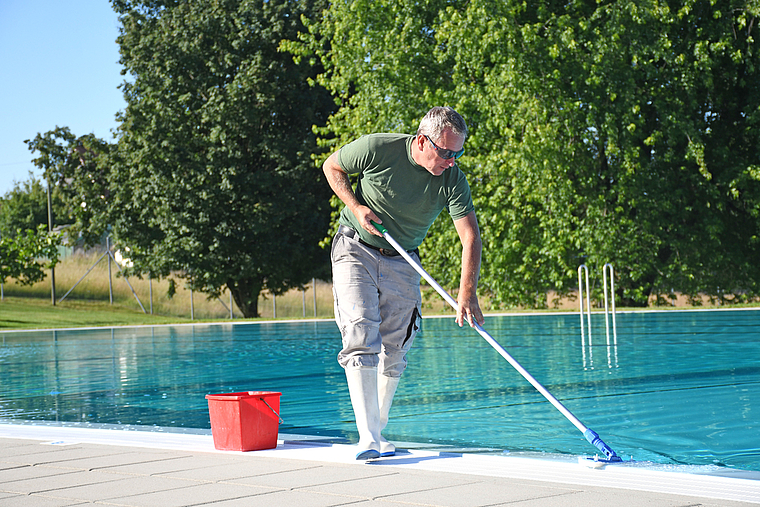 Die Vorbereitungen laufen: Bademeister Jürg Keller reinigt den Rand des Schwimmbeckens mit Chlor. (Bild Livia Häberling)