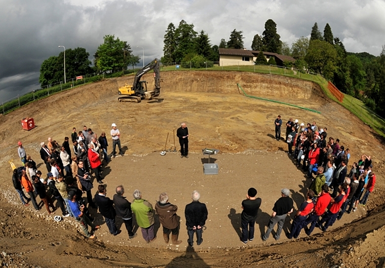Noch hält der Himmel über dem Baugrund für die neue Turnhalle im Albisbrunn dicht. Die dunklen Wolken im Hintergrund künden jedoch den Platzregen an. (Bild Martin Platter)