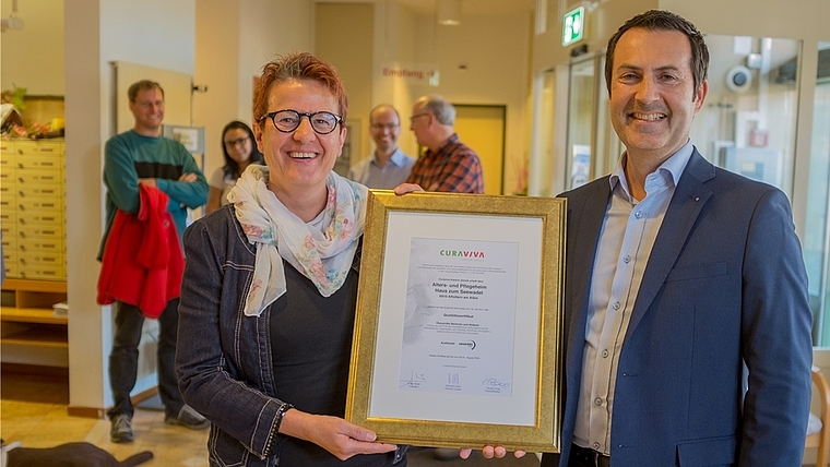 Die Geschäftsleiterin des Seewadels, Verena Feller, nimmt von Michael Oldani von Cura Viva das Qualitätszertifikat entgegen. (Bild Salomon Schneider)