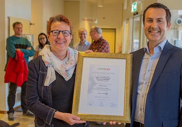 Die Geschäftsleiterin des Seewadels, Verena Feller, nimmt von Michael Oldani von Cura Viva das Qualitätszertifikat entgegen. (Bild Salomon Schneider)