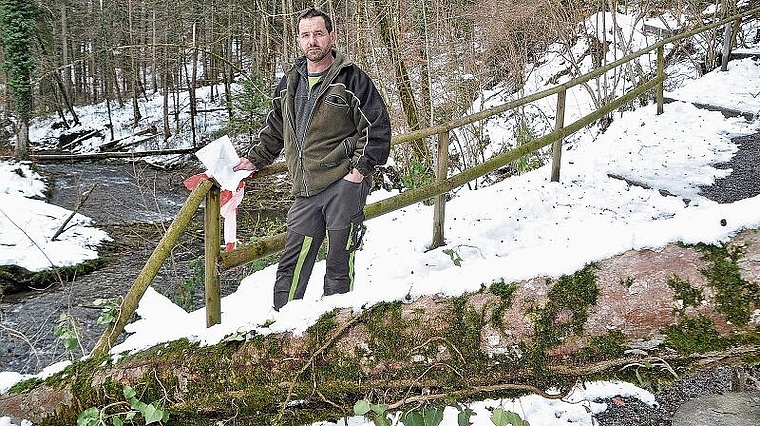 Mehr als anderswo hat der starke Schneefall Bäume im Jonentobel zu Fall gebracht: Förster Ueli Müller mit Fallholz, das über einem Wanderweg liegt. (Bild Werner Schneiter)