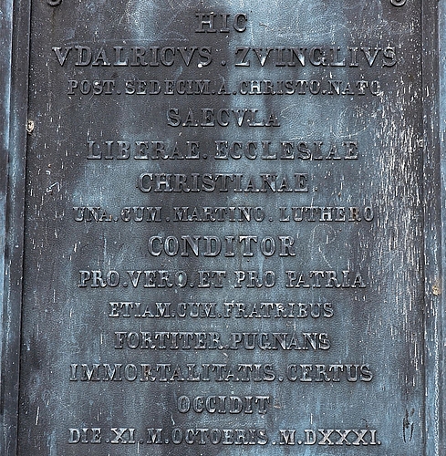 Die Zug zugewandte lateinische Inschrift des Zwingli-Steins ist bemerkenswert. In der Sprache der katholischen Kirche wurde ein aggressiverer Wortlaut gewählt: «Ulrich Zwingli, der im 16. Jahrhundert nach Christi Geburt gemeinsam mit Martin Luther Die Zug zugewandte lateinische Inschrift des Zwingli-Steins ist bemerkenswert. In der Sprache der katholischen Kirche wurde ein aggressiverer Wortlaut gewählt: «Ulrich Zwingli, der im 16. Jahrhundert nach Christi Geburt gemeinsam mit Martin Luther die freie christliche Kirche gründete, starb für die Freiheit und das Vaterland, gemeinsam mit seinen Brüdern, in tapferem Kampf, der Unsterblichkeit gewiss.»
