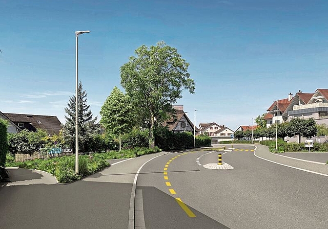 Der angepasste Bereich bei der Bächlerstrasse. Das Trottoir ist neu durchgängig. Dorfaufwärts besteht ein Radstreifen. Vorne mittig auf dem Bild sieht man das Belagsband, welches für die Einfahrt unterbrochen wird und für eine visuelle Schmäler