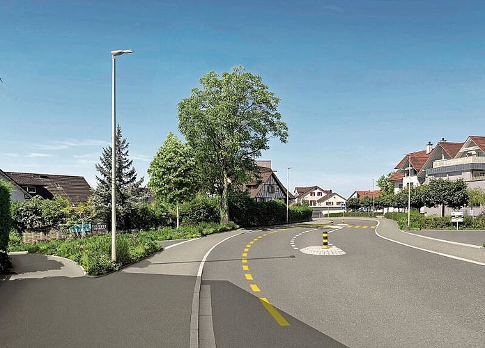 Der angepasste Bereich bei der Bächlerstrasse. Das Trottoir ist neu durchgängig. Dorfaufwärts besteht ein Radstreifen. Vorne mittig auf dem Bild sieht man das Belagsband, welches für die Einfahrt unterbrochen wird und für eine visuelle Schmälerung der Strasse sorgt. (Visualisierung Suter von Känel Wild AG)
