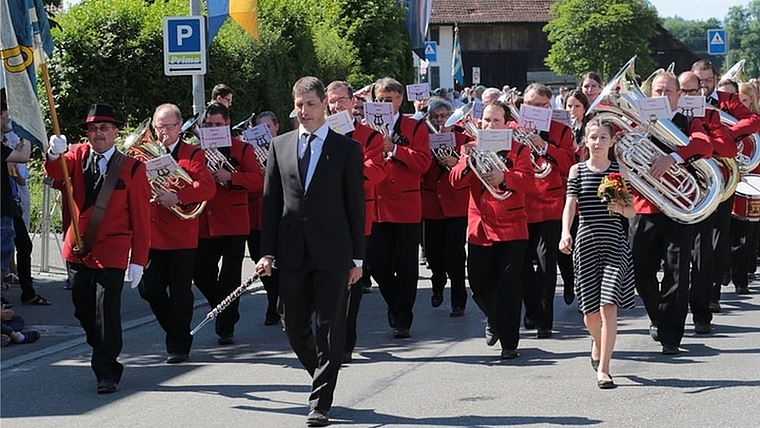 Musikverein Maschwanden marschiert und musiziert auf der glühend heissen Strasse in Tägerig. (Bild zvg.)