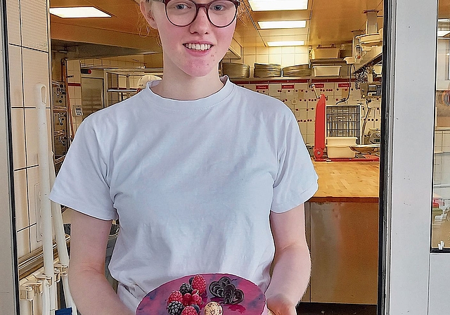 Cora Bollier zeigt ein Beispiel einer Torte, die in ihrem Lehrbetrieb gefertigt wird. (Bilder Marcus Weiss)