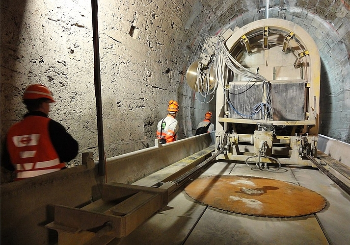 Die Gewölbefräse schafft Platz für massive Betonrippen mit Stahlträgern.Überall Risse und Wasser: das Gewölbe vor der Sanierung.Überraschend dick: die Betonschicht vor dem Portal auf Wettswiler Seite.Solider als es den Anschein macht: Das Tuffsteingewölbe in der Mitte des Tunnels.Abtransport: Der Schutt muss quer durch den Tunnel.Schalung für den neuen Portalvorbau auf Birmensdorfer Seite.Die Betonsohle wird eingebaut. (Bilder SBB / Amberg / tst.)Graben für neue Entwässerungsleitungen.