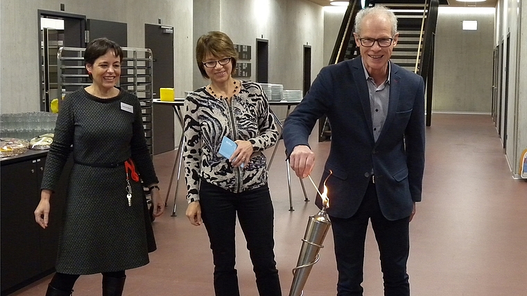 Martin Gallusser, Sozialvorstand in Affoltern, entzündet das olympische Lesefeuer. Neben ihm Fabienne Maurer (ganz links), Leiterin Bibliothek Wettswil, und Irene Scheurer von der Regionalbibliothek Affoltern. (Bild Marianne Voss)
