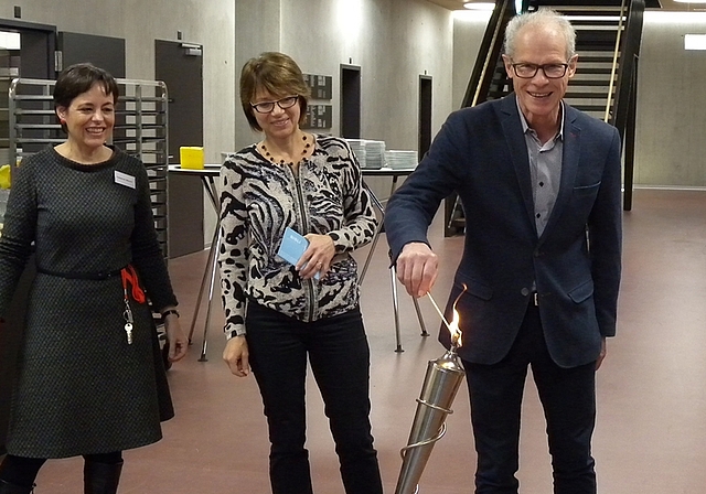Martin Gallusser, Sozialvorstand in Affoltern, entzündet das olympische Lesefeuer. Neben ihm Fabienne Maurer (ganz links), Leiterin Bibliothek Wettswil, und Irene Scheurer von der Regionalbibliothek Affoltern. (Bild Marianne Voss)